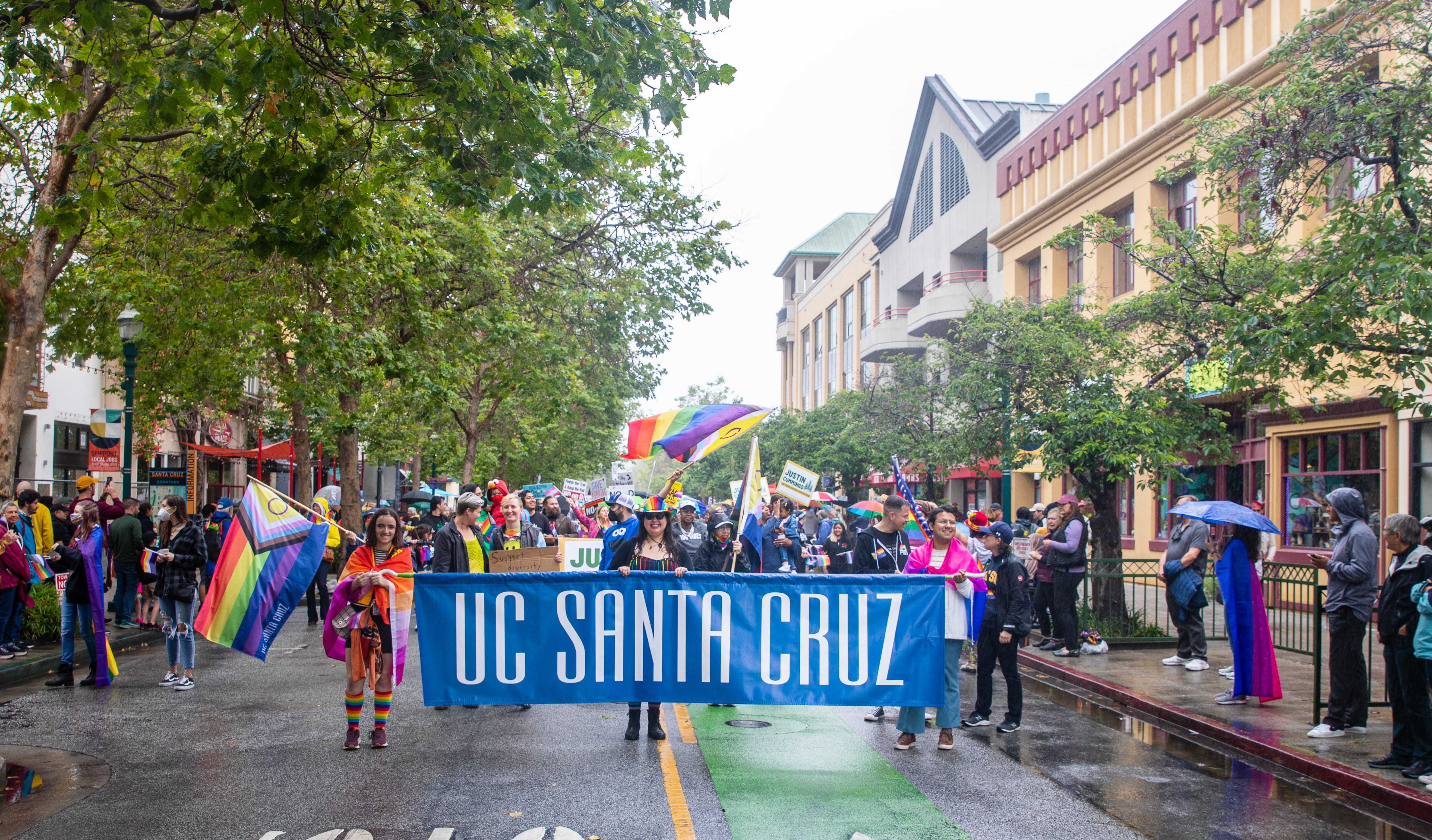 parade with people holding banner that says UC Santa Cruz