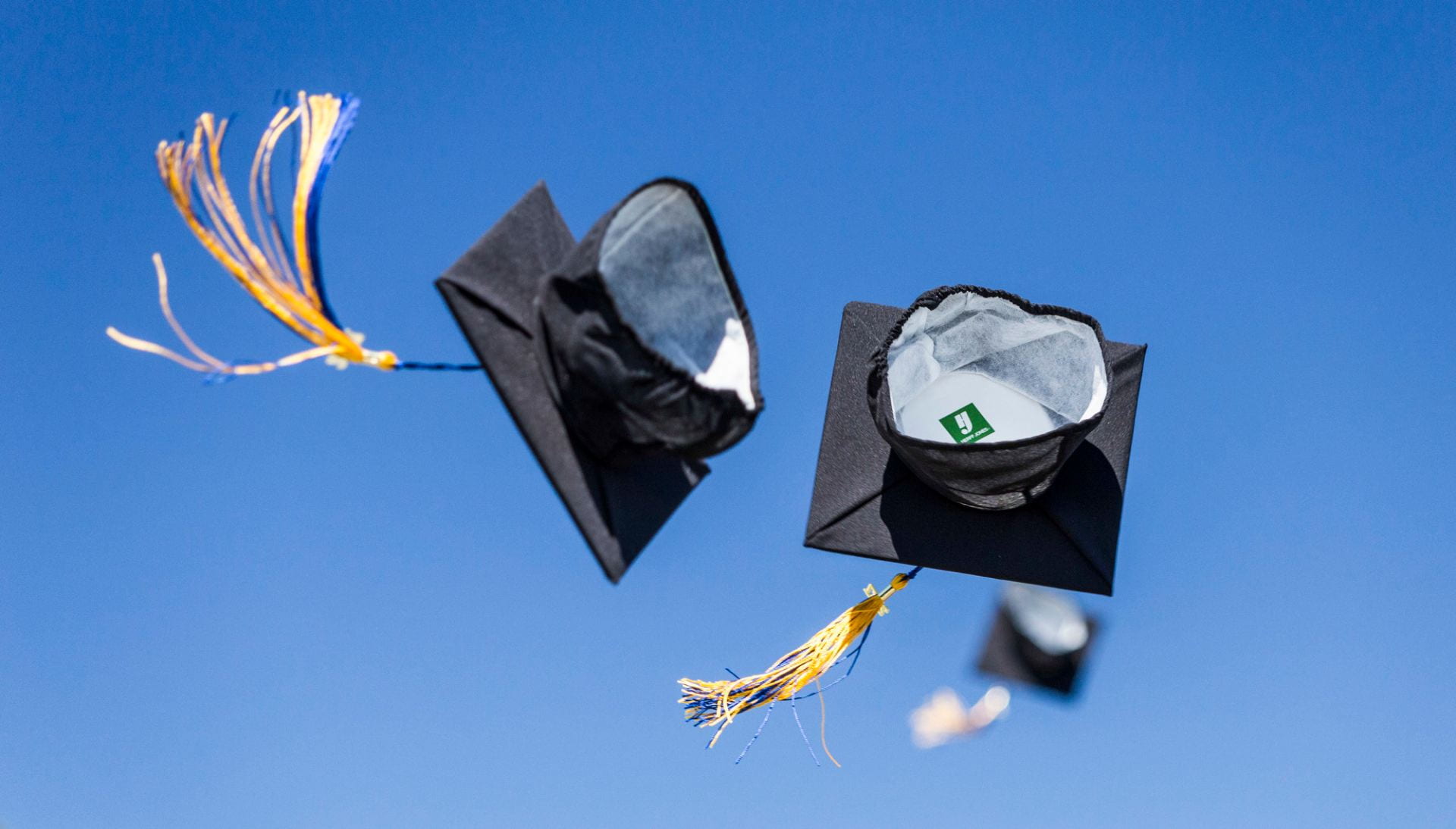 graduation caps flying through the air